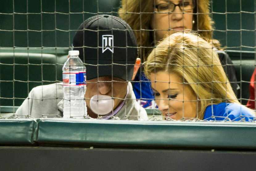 Johnny Manziel blows a bubble as he watches from the seats behind home plate as the Texas...