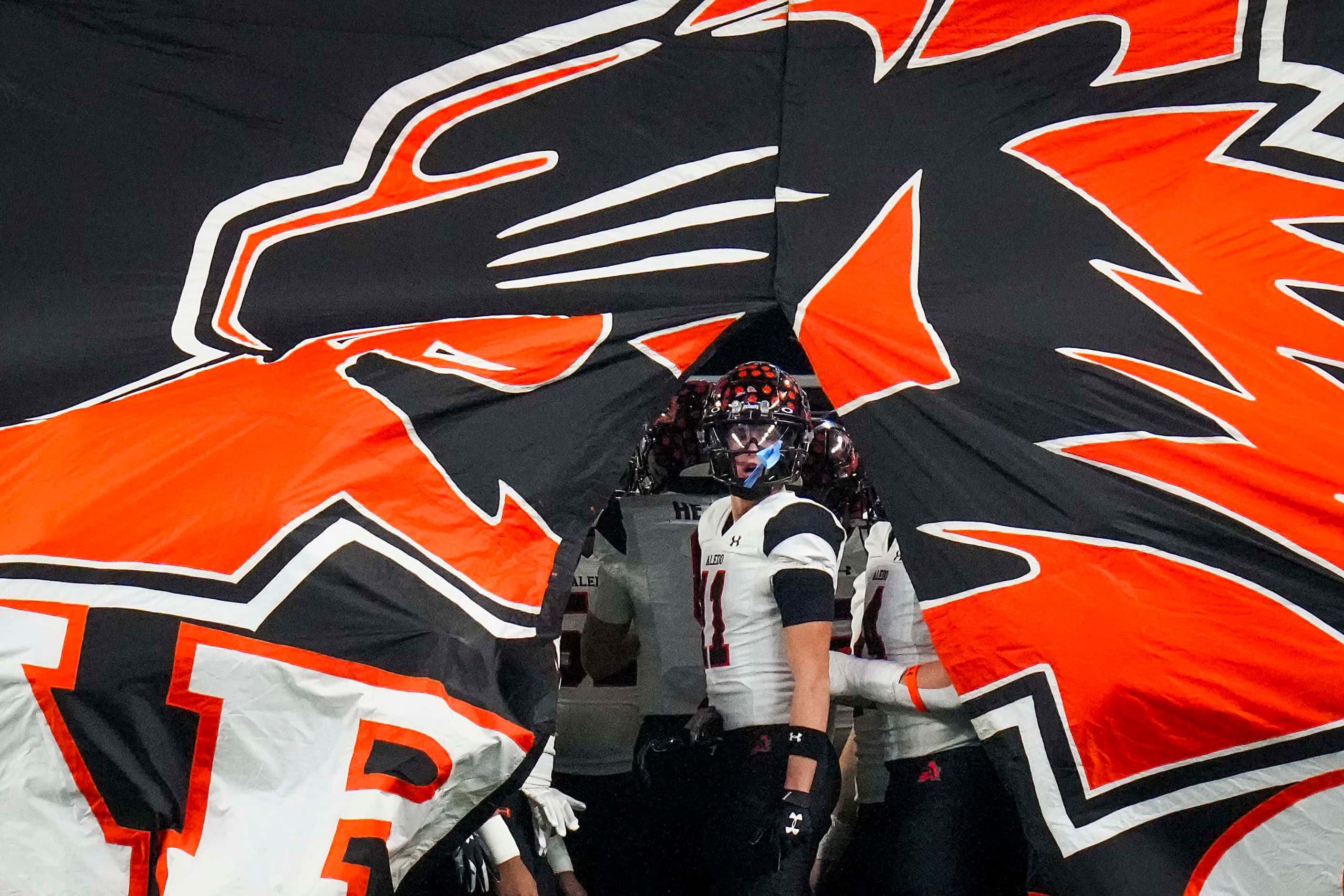 Aledo wide receiver Trace Clarkson (11) breaks through the banner as the Bearcats take the...