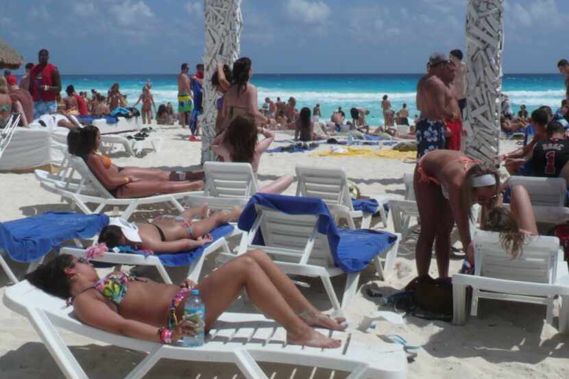 Sunbathers gather along the beach in Cancun.  The resort area has been the site of increased...
