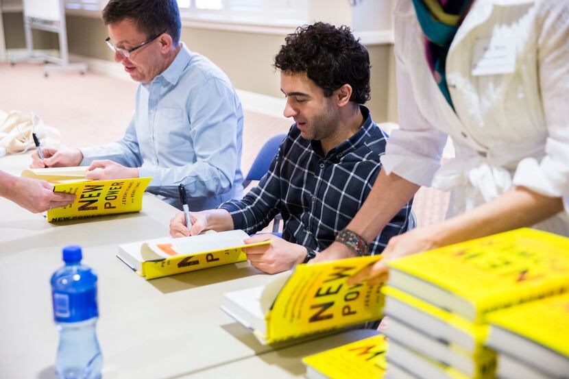 Henry Timms, left, and Jeremy Heimans sign copies of their book, New Power: How Power Works...