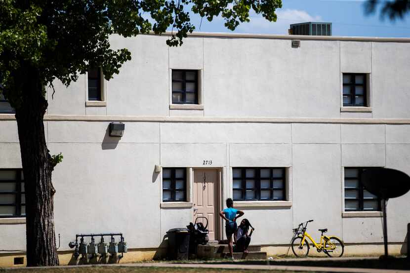 Girls chat outside a building at Cedar Springs Place on June 29, 2018. The Dallas Housing...