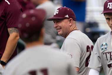 Texas A&M coach Jim Schlossnagle smiles in the dugout before his team plays against...