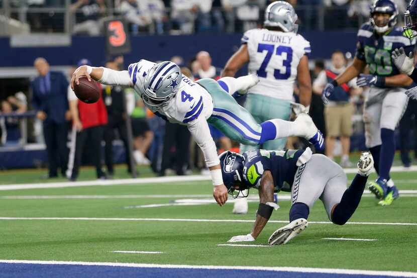 Dallas Cowboys quarterback Dak Prescott (4) dives for more yards but is stopped by Seattle...
