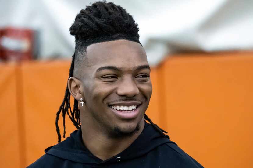 Texas running back Bijan Robinson, looks on from the sidelines as he watches other players...