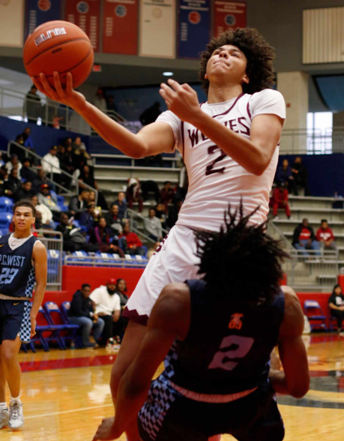 Mansfield Timberview junior Cameron Taylor (2) drives the lane to shoot over Putnam City...