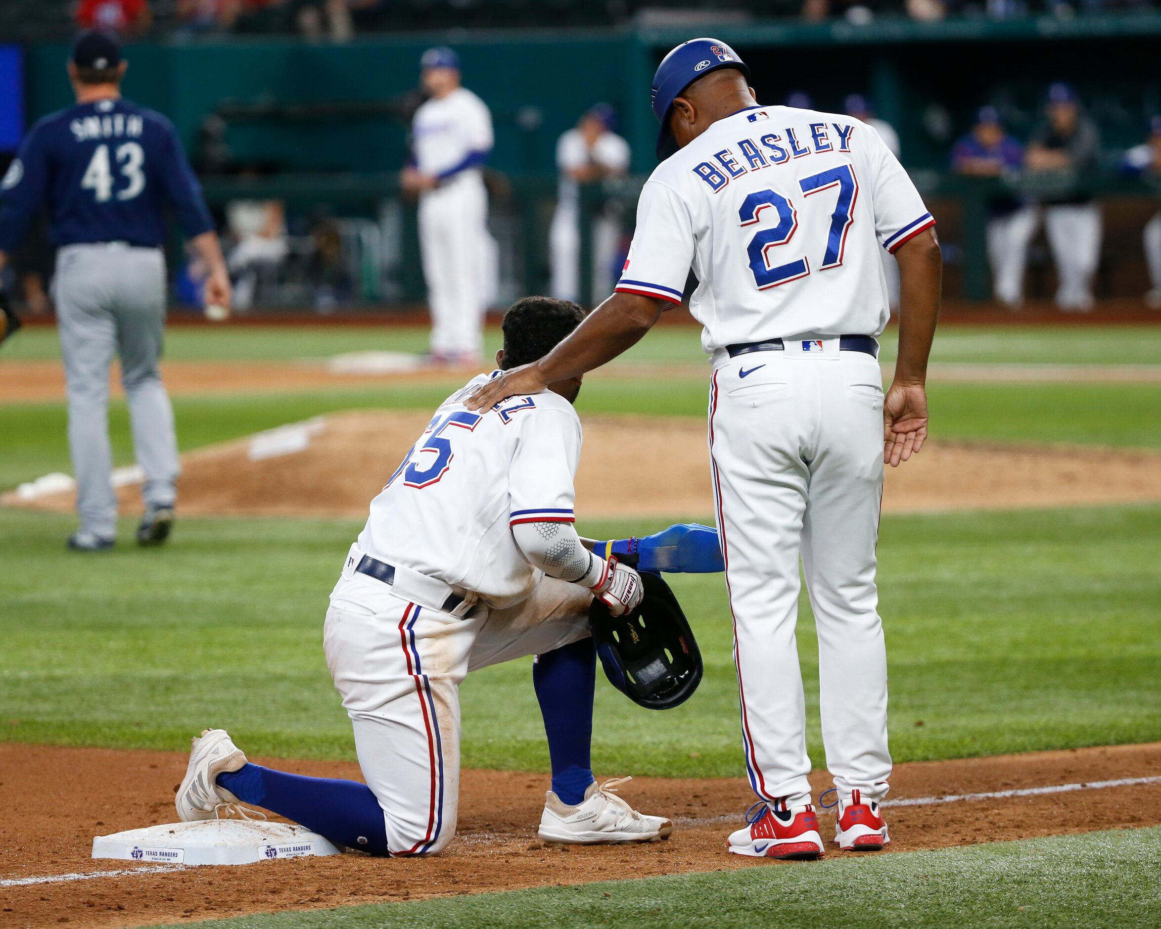 Texas Rangers third base coach Tony Beasley (27) speaks with Texas Rangers second baseman...