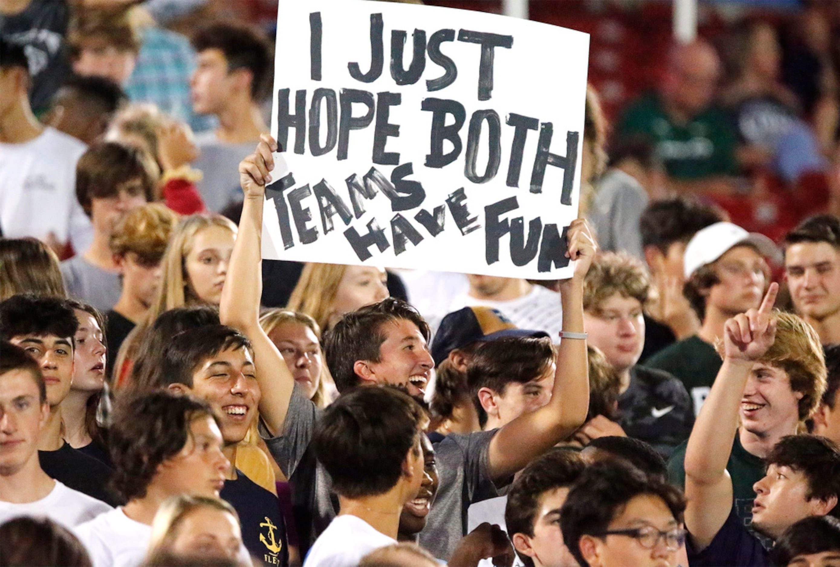 David Prinsloo, 16, of Frisco, holds up a sign in the Reedy High School student section...