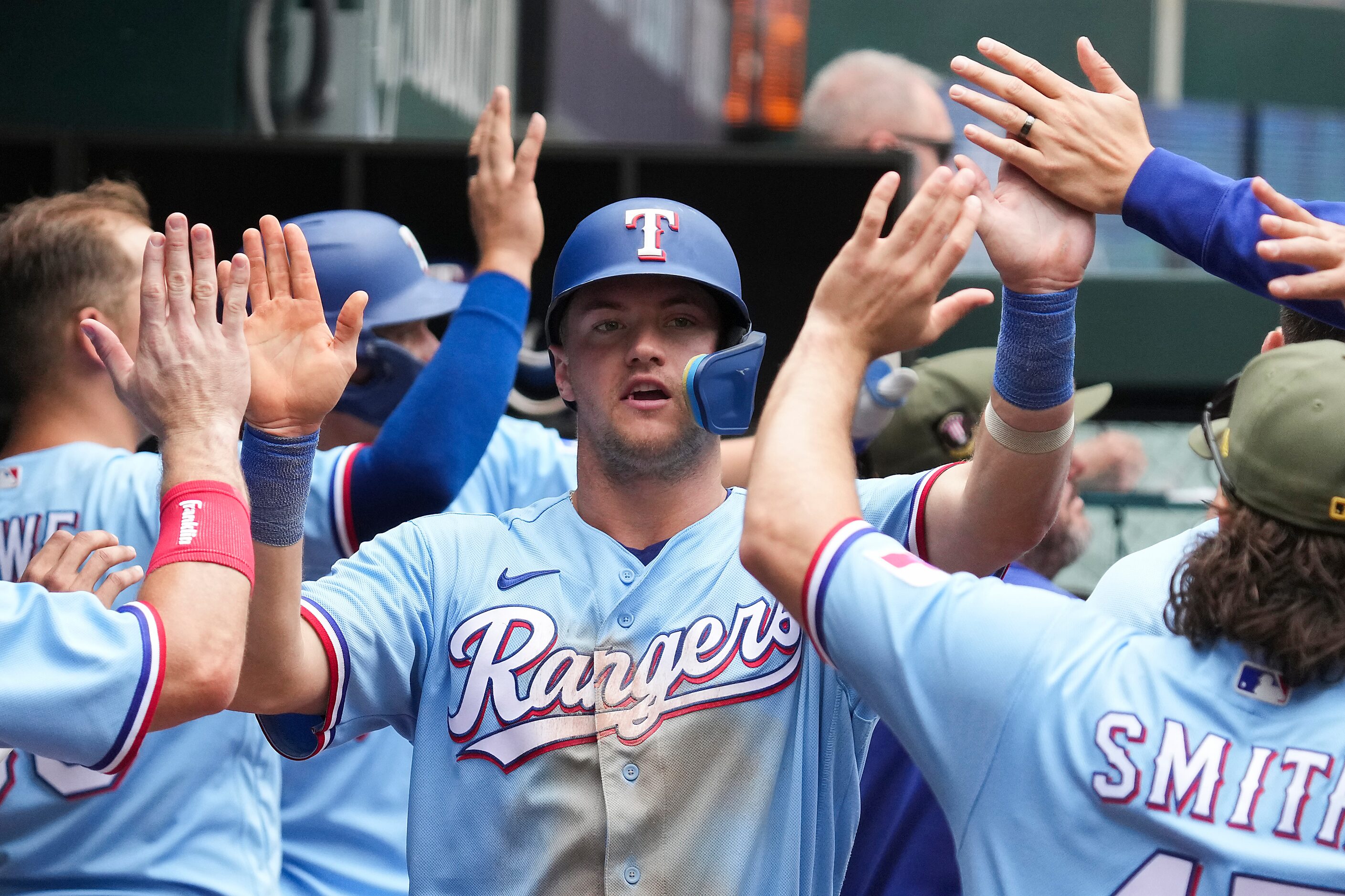 Texas Rangers third baseman Josh Jung celebrates in the dugout after scoring on a...