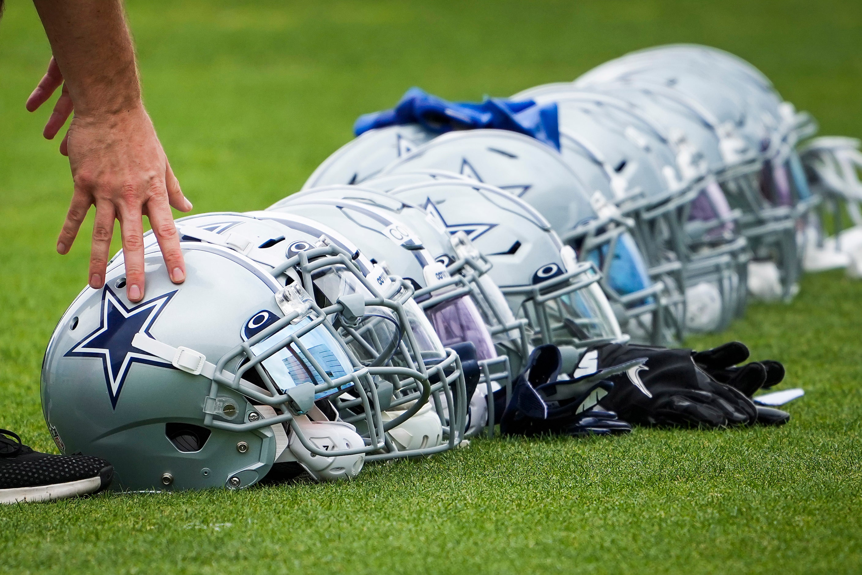 Dallas Cowboys helmets lined up on the sidelines during a minicamp practice at The Star on...