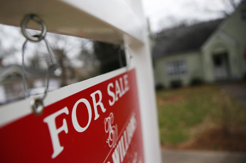 
FILE - This Jan. 26, 2016 file photo shows a "For Sale" sign hanging in front of an...