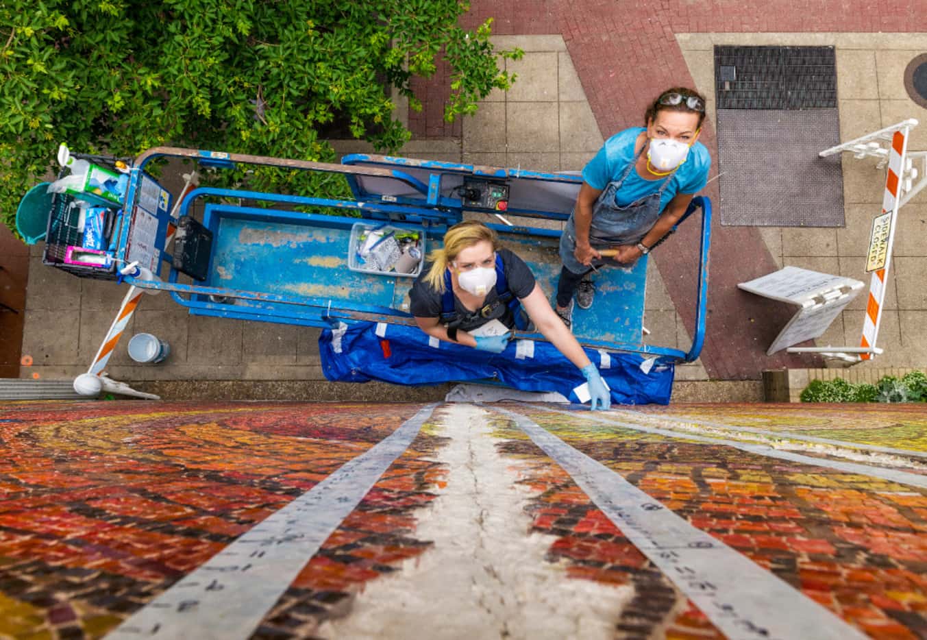 Callie Heimburger and Julie Richey work to remove cracked mortar, reinforce the gap and...