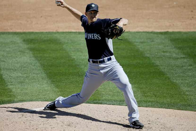 Seattle Mariners starting pitcher Scott Baker throws to the Oakland Athletics during the...