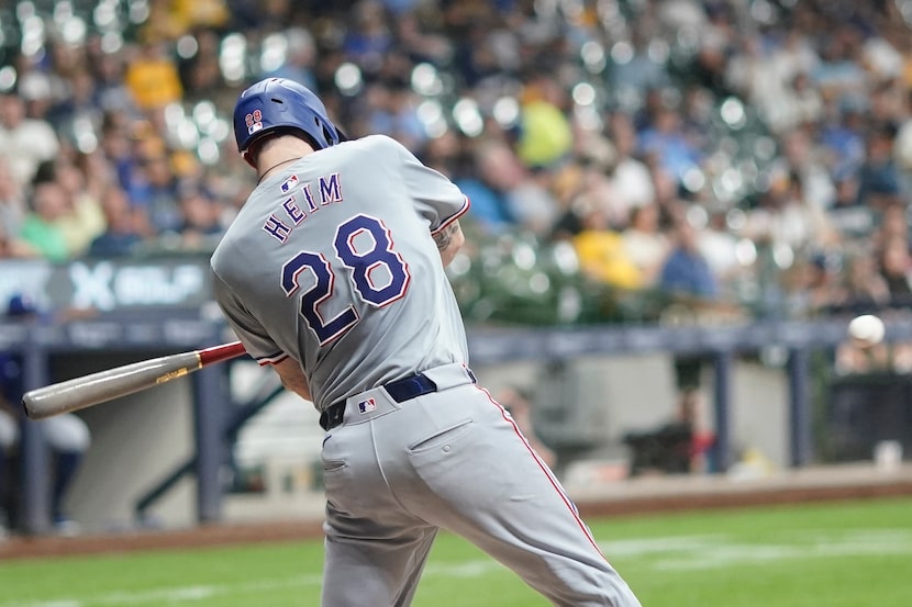 Texas Rangers' Jonah Heim hits a single during the eighth inning of a baseball game against...