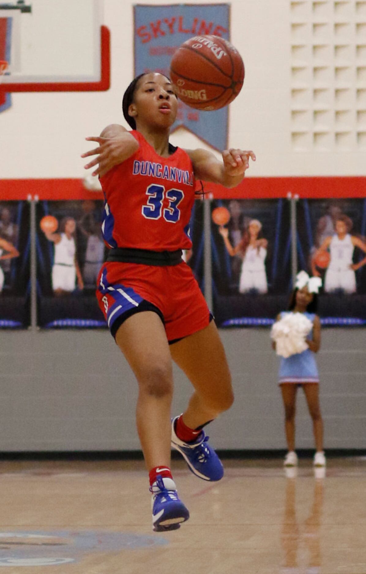Duncanville's Nyah Wilson (33) delivers a running pass to a teammate during first half...