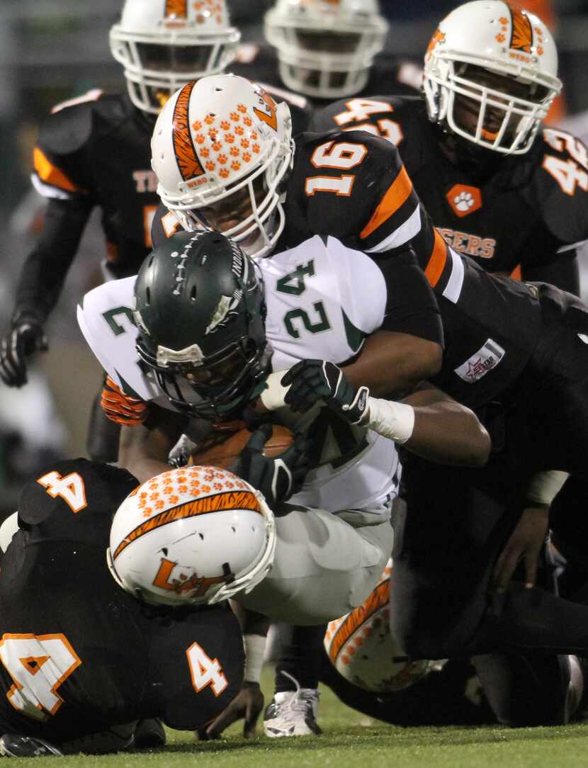 Waxahachie Indians running back Treyvon Hughes (24) is stopped in his tracks at the line of...