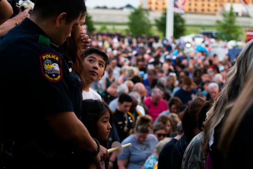 Eric Molina looks up at his father, Grand Prairie police Officer Edgar Molina, as his...