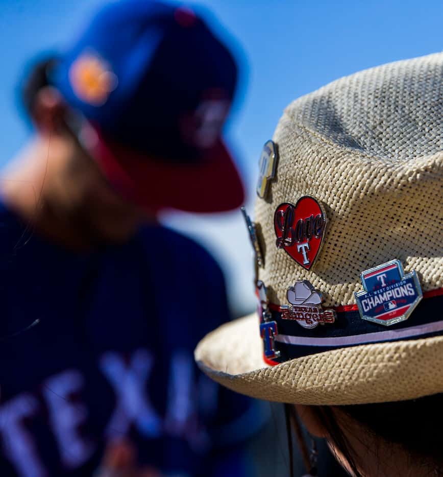 A fan wears Texas Rangers pins on her hat as Texas Rangers starting pitcher Yu Darvish (11)...