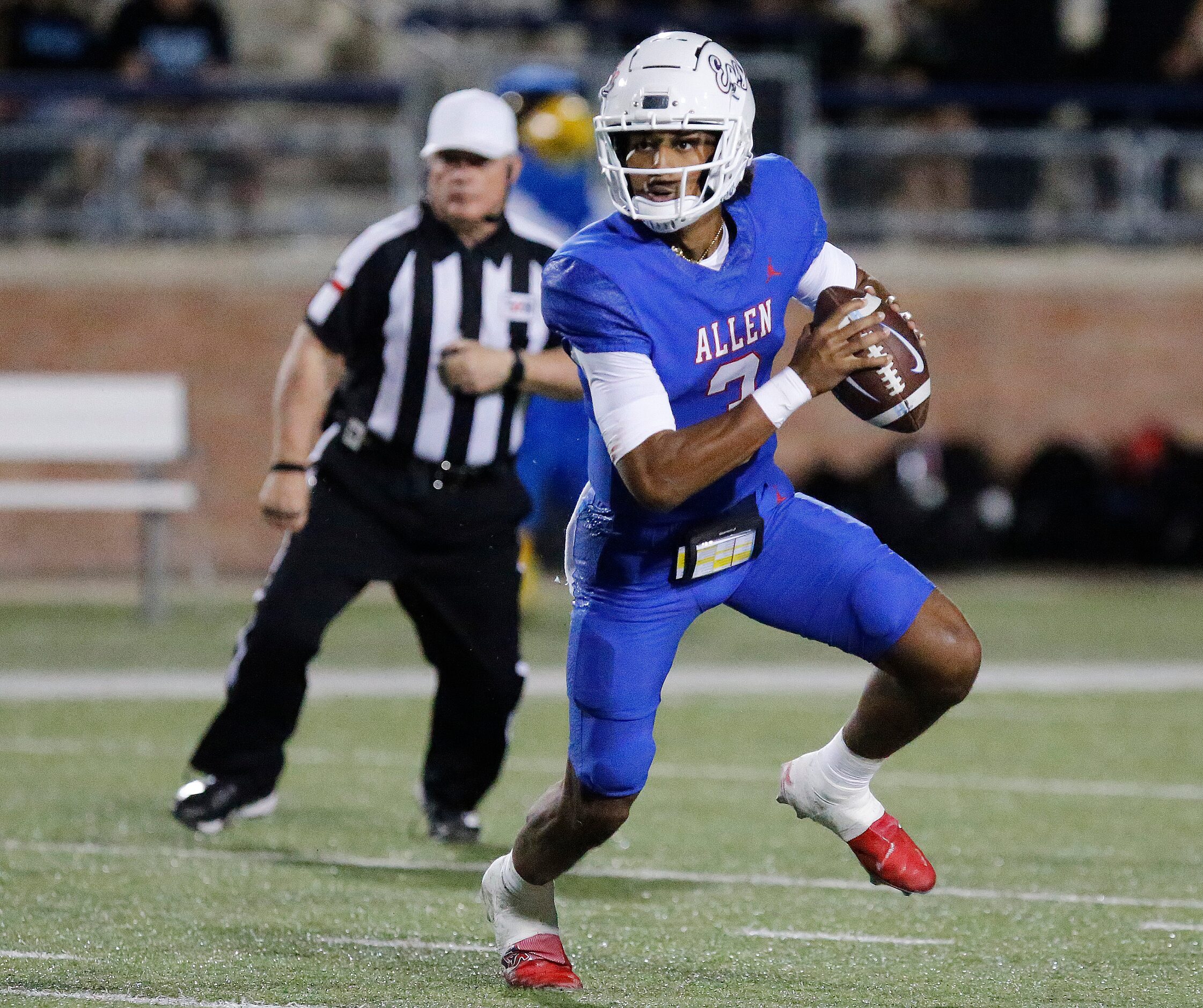 Allen High School quarterback Mike Hawkins (3) rolls out during the first half as Allen High...