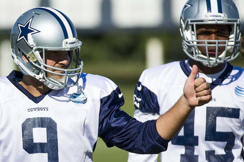 Dallas Cowboys quarterback Tony Romo (9) gives a thumbs up to teammates during practice at...