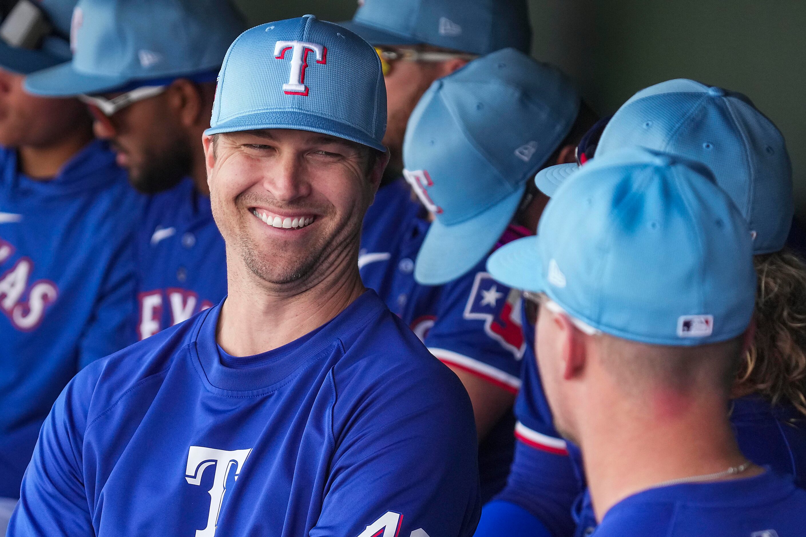 Texas Rangers pitcher Jacob deGrom laughs with infielder Josh Jung (right) in the dugout...