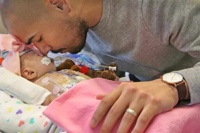 Dallas ISD trustee Miguel Solis spent a quiet moment with daughter Olivia in intensive care...