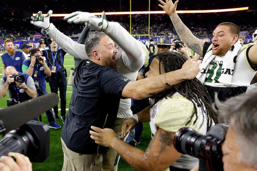 Baylor head coach Matt Rhule, center left, embraces his players as they celebrate their...