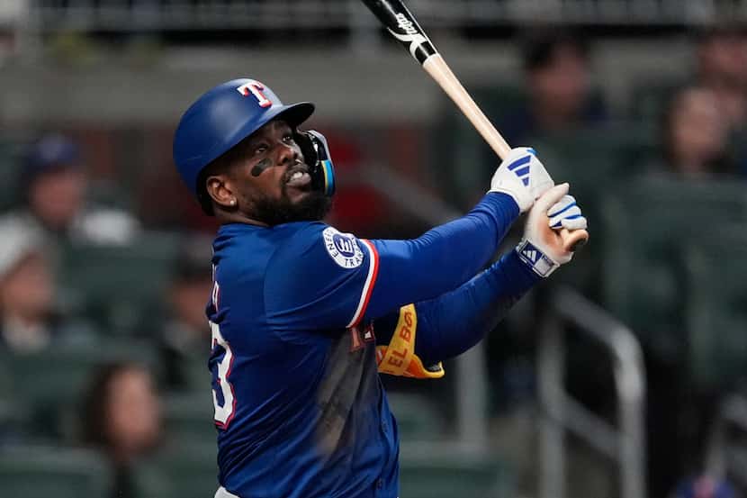 Texas Rangers' Adolis García watches a two-run home run in the eighth inning of a baseball...