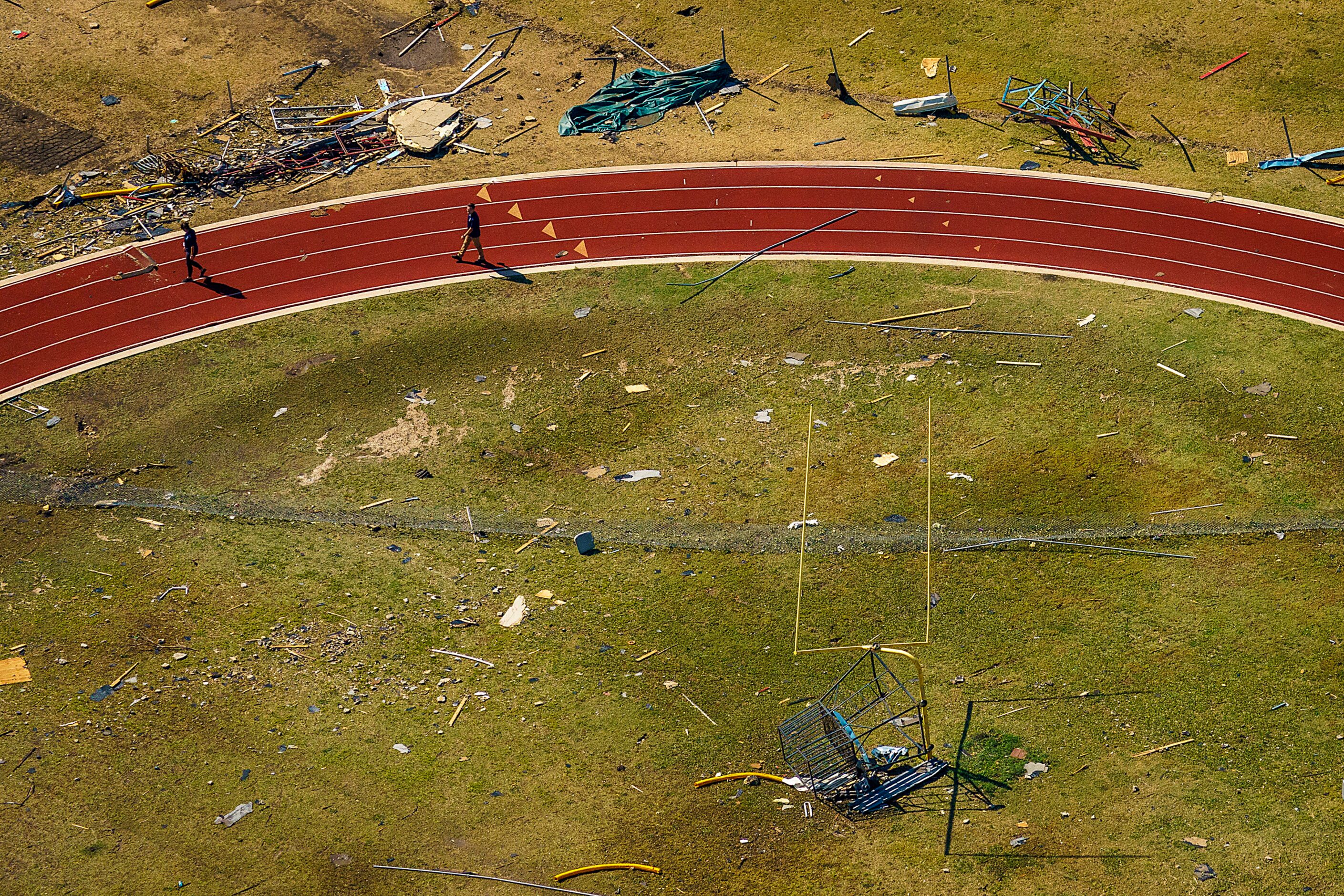 Rubble from tornado damage is strewn across an athletic field at Thomas Jefferson High...