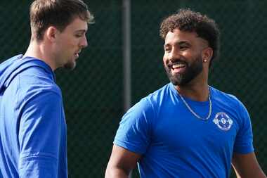 Texas Rangers Ezequiel Duran (right) laughs with outfielder Evan Carter during a spring...