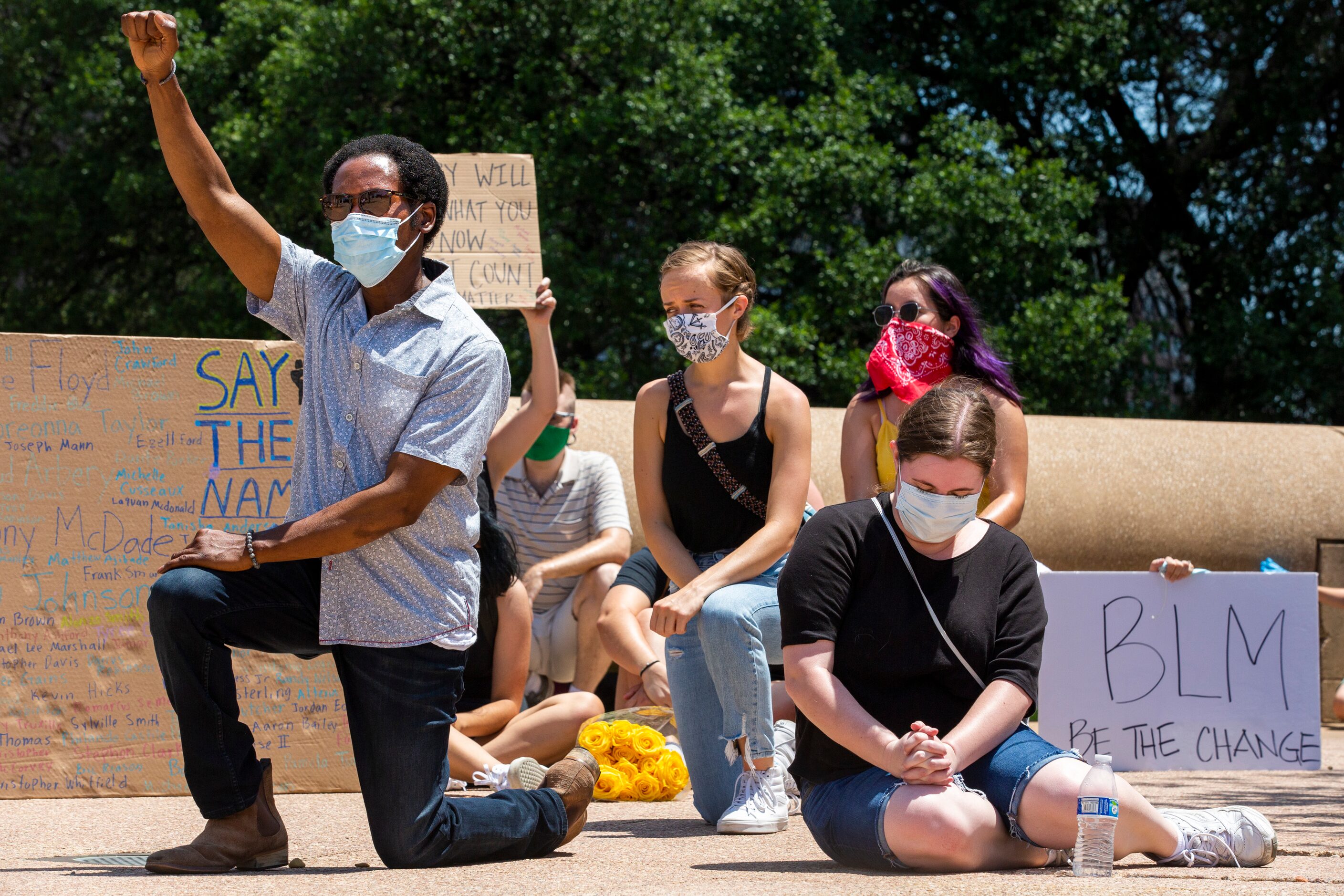 Frederick Jones (left) raises his fist as protesters participate in an 8-minute and...