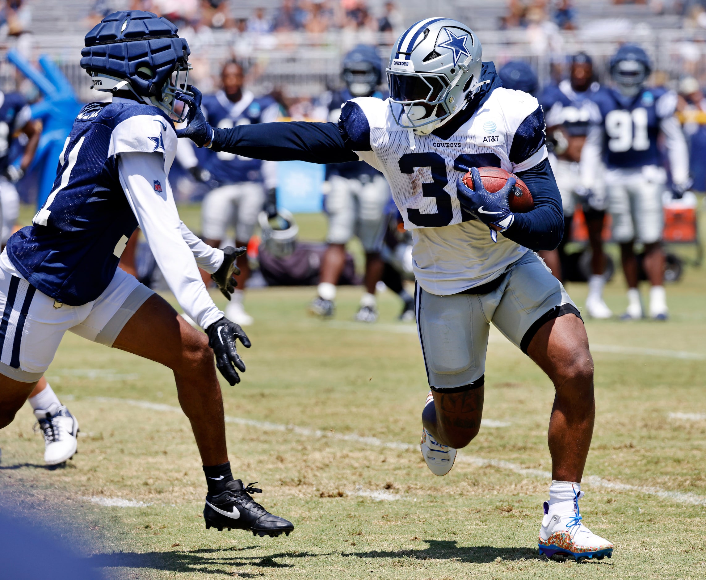 Dallas Cowboys running back Snoop Conner (32) stiff arms cornerback Josh Butler (31) as he...