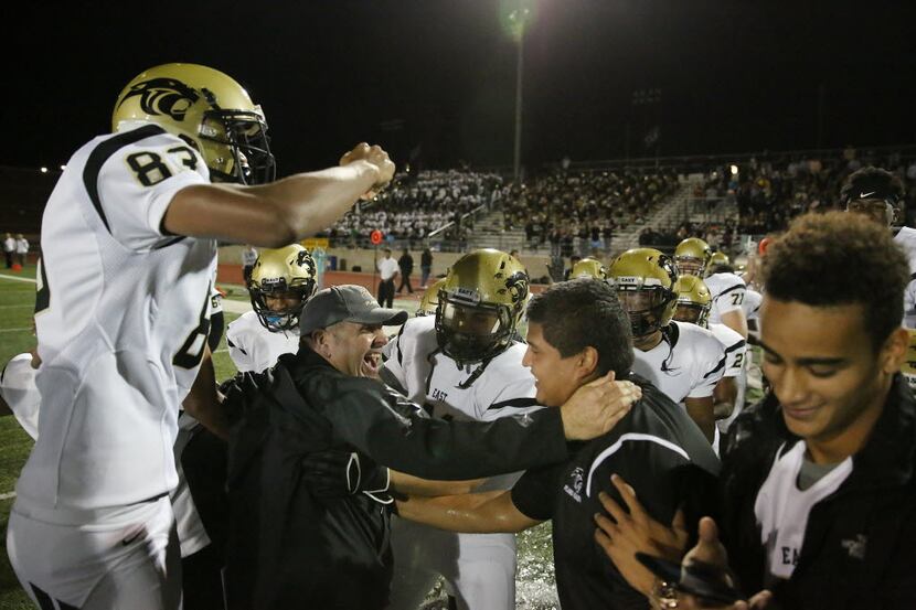 Plano East head coach Joey McCullough (bottom left) celebrates with his team after a high...