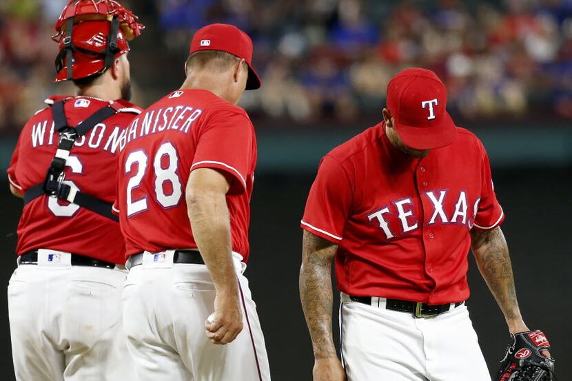 Texas Rangers relief pitcher Matt Bush (right) walks off the mound after giving up four runs...