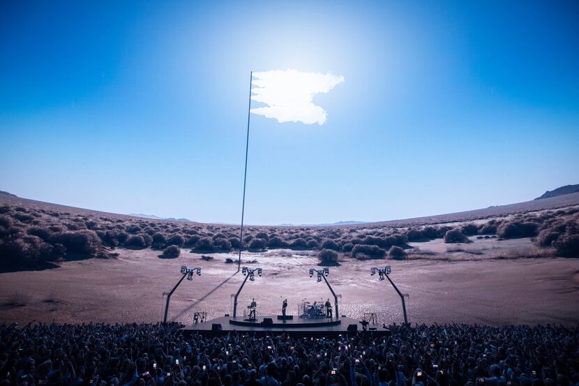 Concertgoers and the rock band U2 are transported to a hyper-realistic desert landscape.