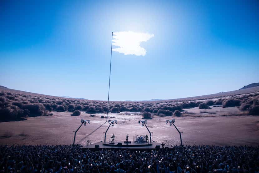 Concertgoers and the rock band U2 are transported to a hyper-realistic desert landscape.
