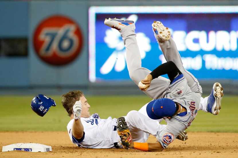 LOS ANGELES, CA - OCTOBER 10:  Ruben Tejada #11 of the New York Mets is hit by a slide by...