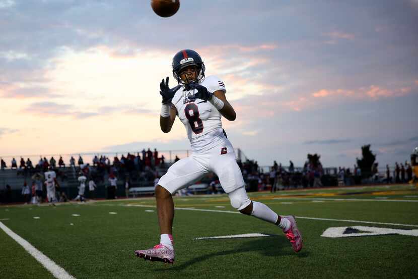 Bishop Dunne player Reginald Roberson (8) catches the ball during warm ups before a high...
