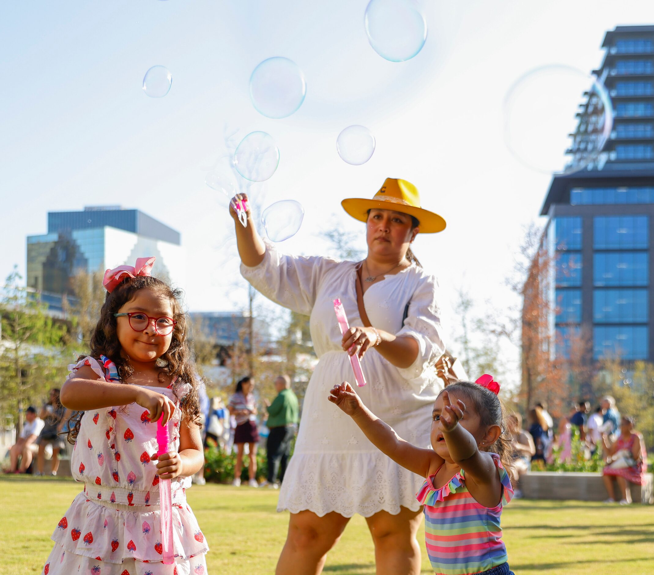 Ava Moreno, (left), 5, and her mother Monica blows soap bubble as Noelle Huerta, 2, (right),...