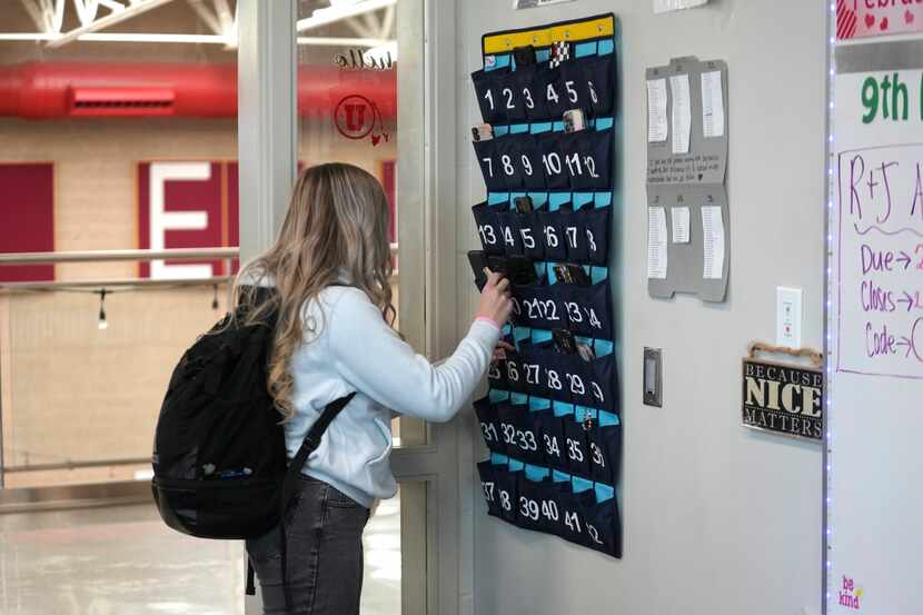 A ninth grader places her cellphone in to a phone holder as she enters class at Delta High...