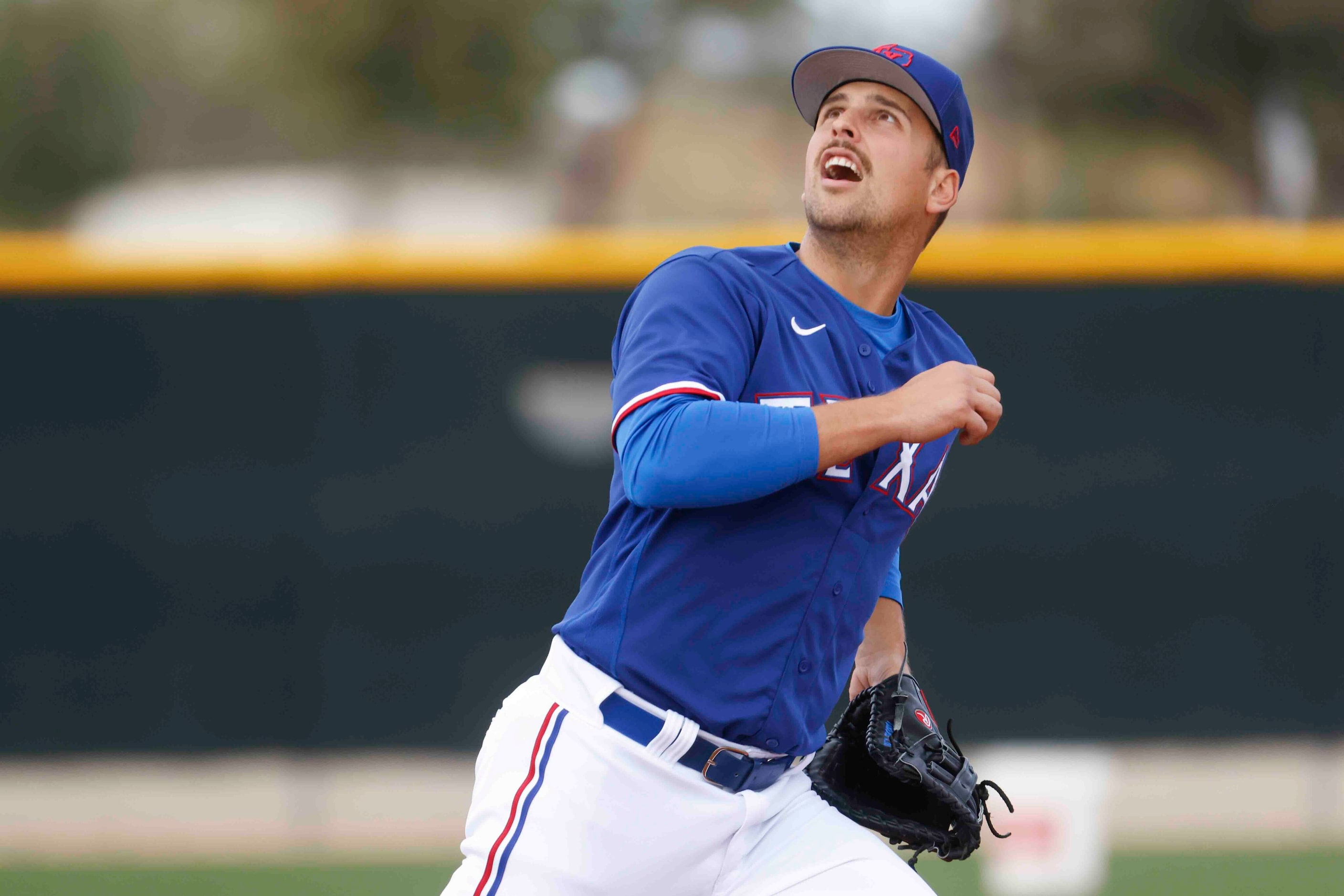 Texas Rangers infielder Nathaniel Lowe gets set to make a catch during a fielding drill at...