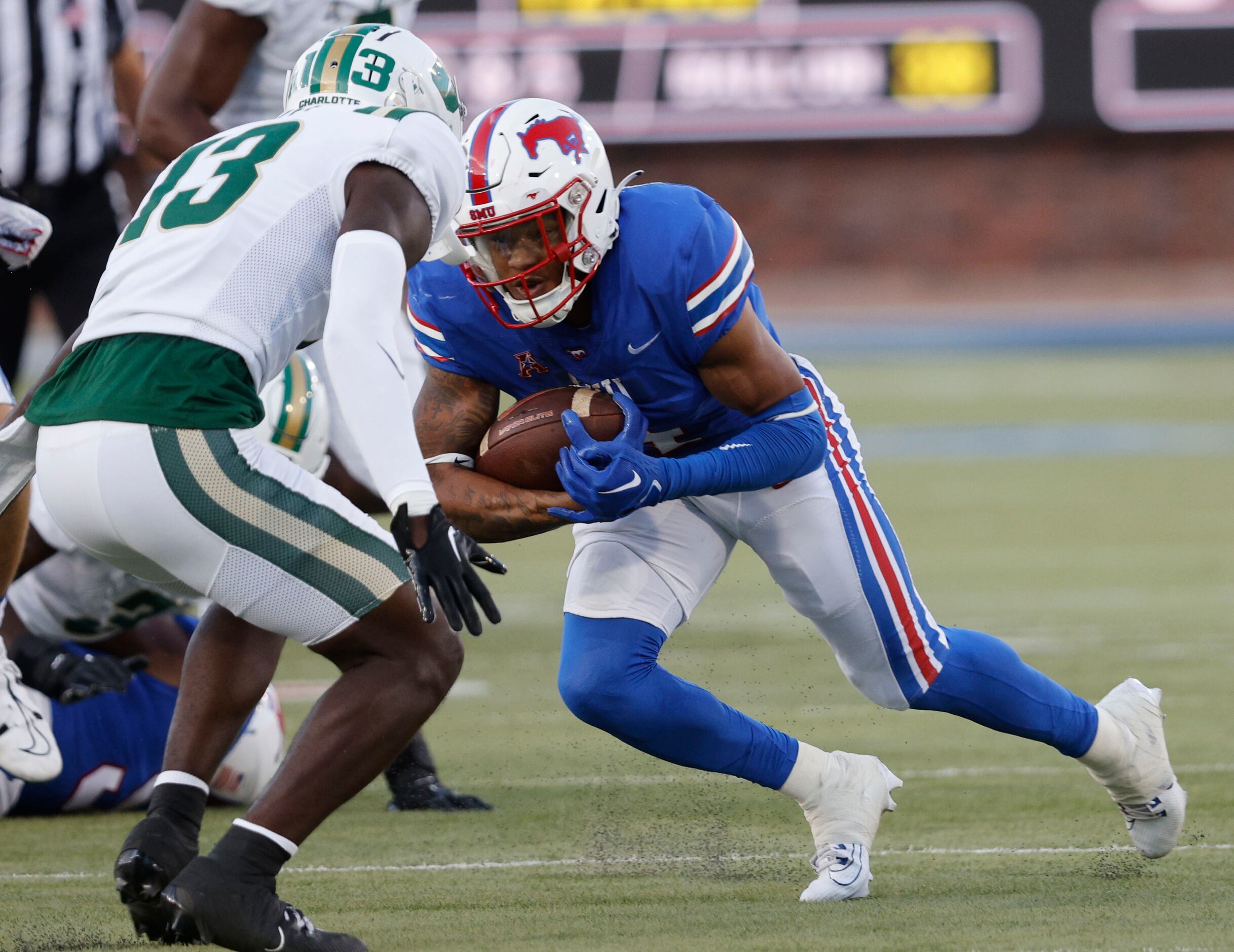 SMU running back Jaylan Knighton (4) carries the ball as Charlotte 49ers defensive back...