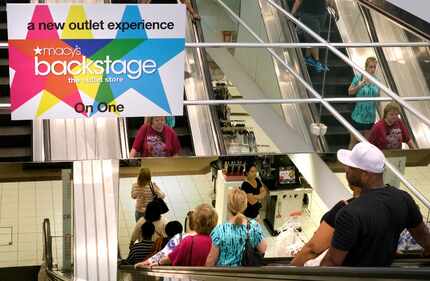 Shoppers fill the escalator during the grand opening of Macy's new Backstage department...