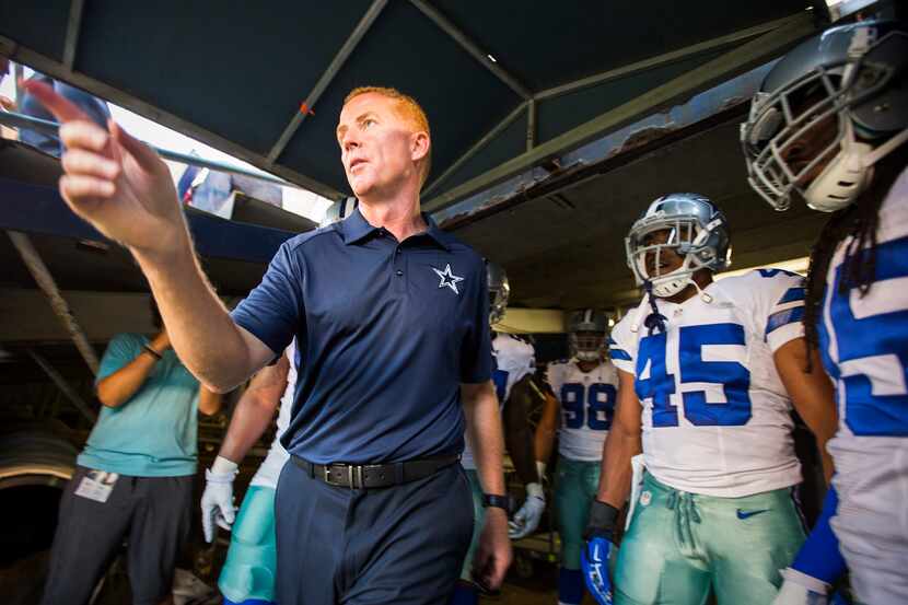 Dallas Cowboys head coach Jason Garrett points his team toward the field as the come out of...