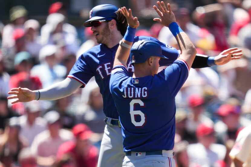 Texas Rangers' Jonah Heim, left, celebrates with Josh Jung (6) after scoring off of a double...