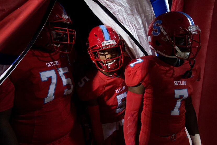 Skyline lineman Richard Franklin (75), cornerback Martinez Hill (5) and linebacker Kamryn...