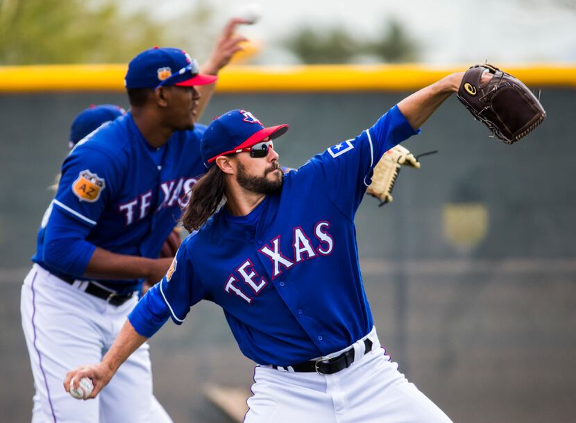 Texas Rangers relief pitcher Tony Barnette (43) and other pitchers warm up during a spring...
