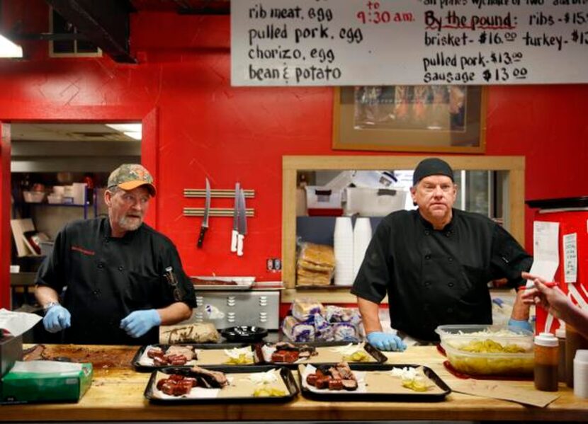 
BBQ on the Brazos pitmaster John Sanford, left, and Michael Warren chat up customers in...