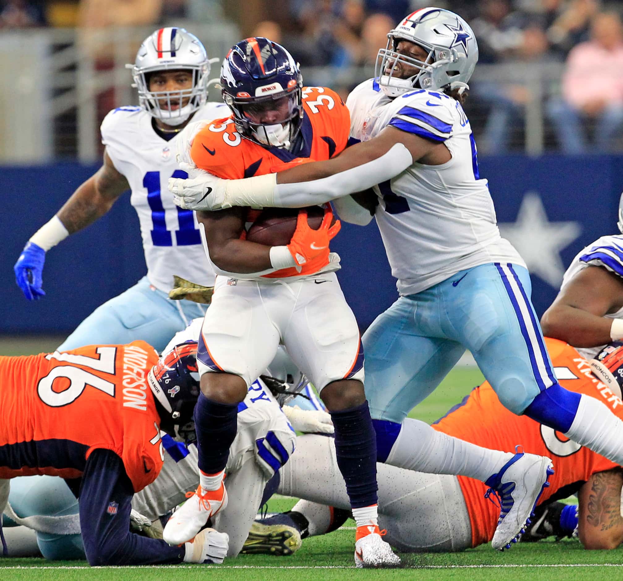 Dallas Cowboys defensive tackle Osa Odighizuwa (97) tackles Denver Broncos cornerback Kary...