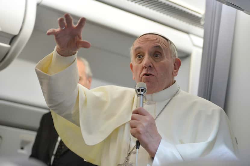 El papa Francisco gesticula mientras responde a las preguntas de los periodistas durante una...