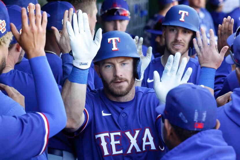 Texas Rangers Robbie Grossman, front, and Mitch Garver celebrates after Garver hits a home...